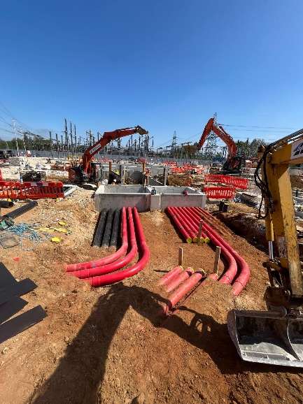 Red HV ducts sweeping into precast draw pits with the substation behind