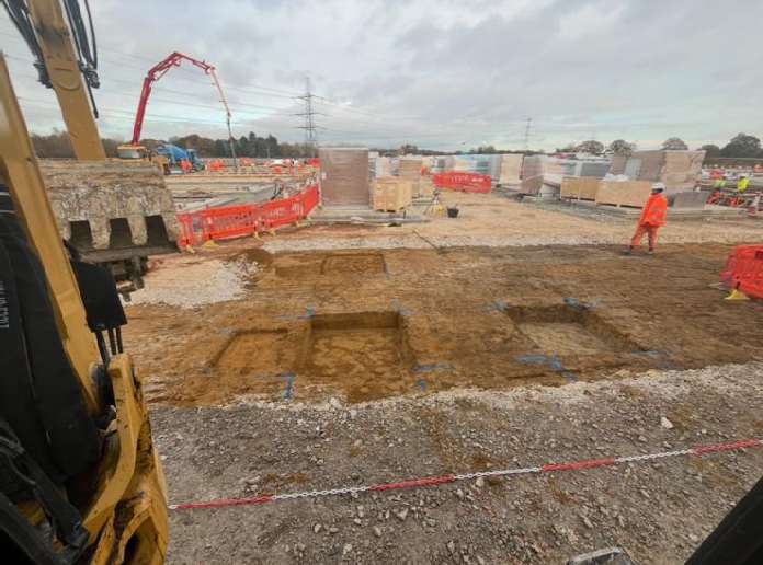 Foundation excavations set out in front of stacked battery units