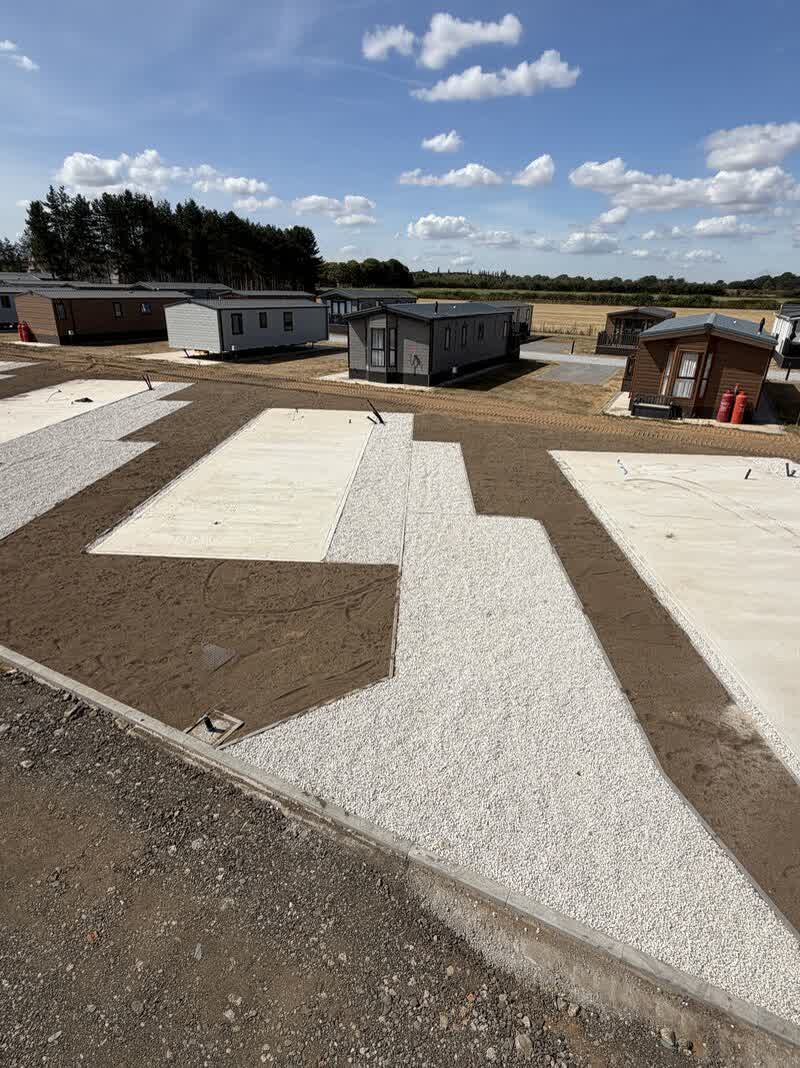 Concrete lodge bases and granular paths laid out across the park